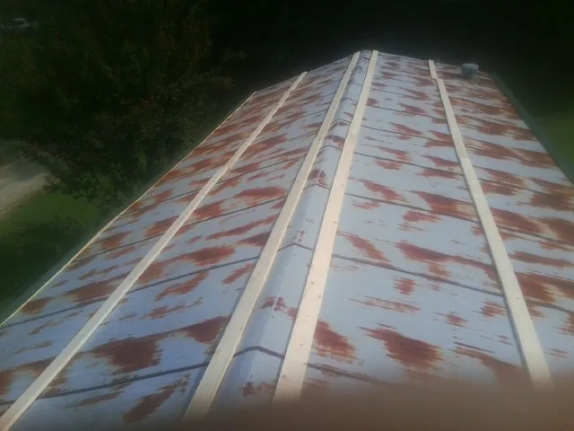 Rusted metal roof panels with new wood purlins before replacement — Storm Damage Roof Repair in Conroe by Roofing Brothers